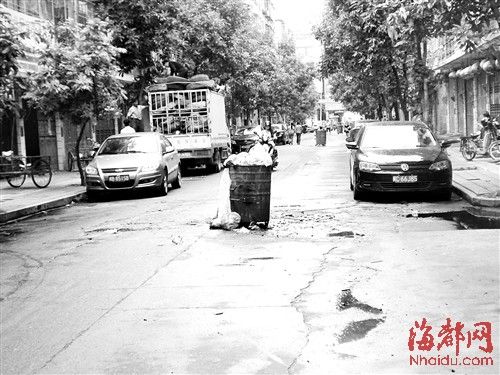 垃圾桶摆在马路中央，给过往的车辆、行人造成麻烦
